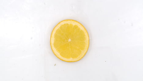 Super-Slow-Motion-Shot-of-Splashing-Water-to-one-orange-Slices-view-from-above